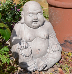 Buddhist Monk statue Sitting down in Weathered Dark Stone